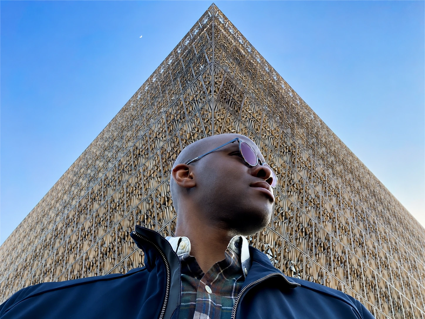 Tope Folarin beneath the bronze architecture of the National Museum of African American History and Culture.